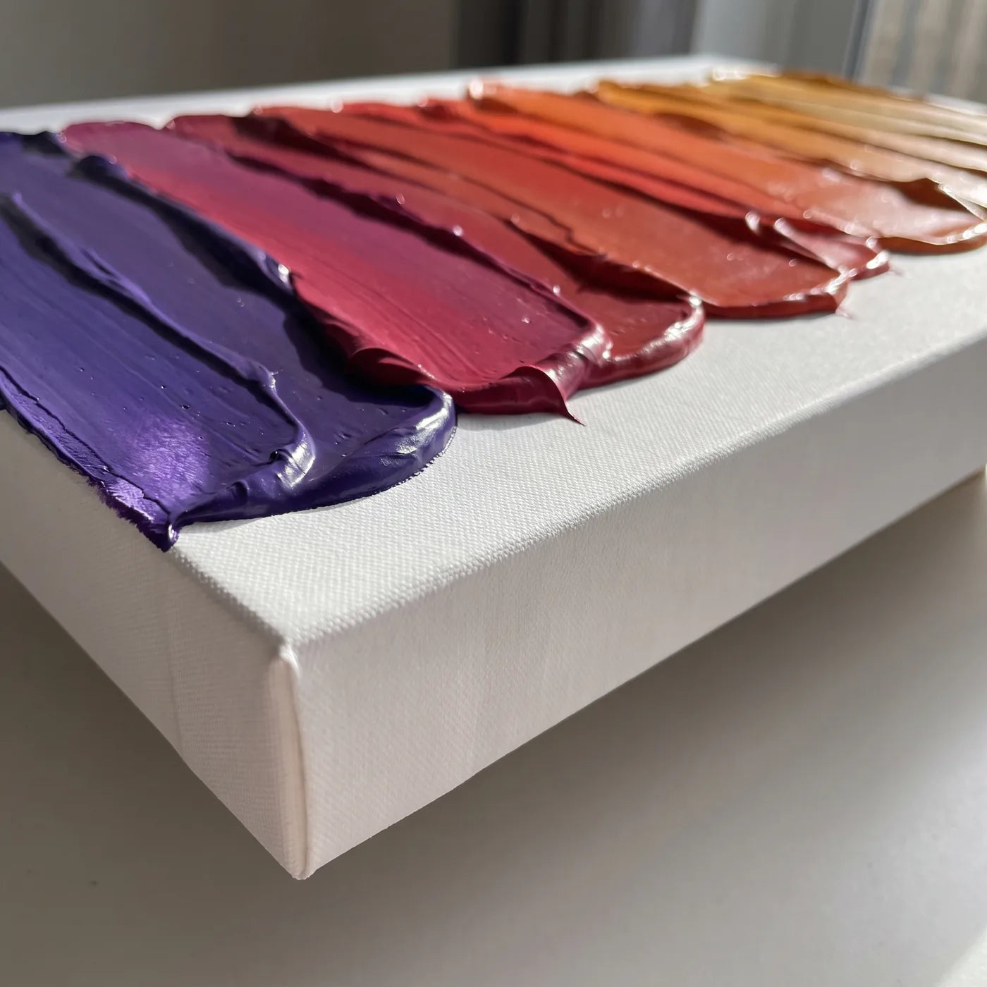 Hrana plátna 3D+ z boku — biely bok s hĺbkou 5,8 cm a pásy hustej akrylovej farby nanášané špachtľou, každý v inej farbe, spolu tvoriace prechod od fialovej po jantár